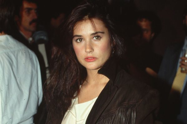 1985: Actress Demi Moore shown standing, wearing a fringed, leather coat.